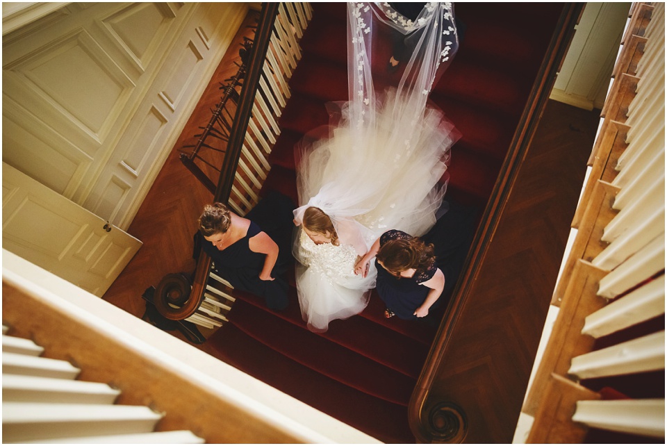 Bride and bridesmaids walk down the stairs at Allerton Park Mansion.