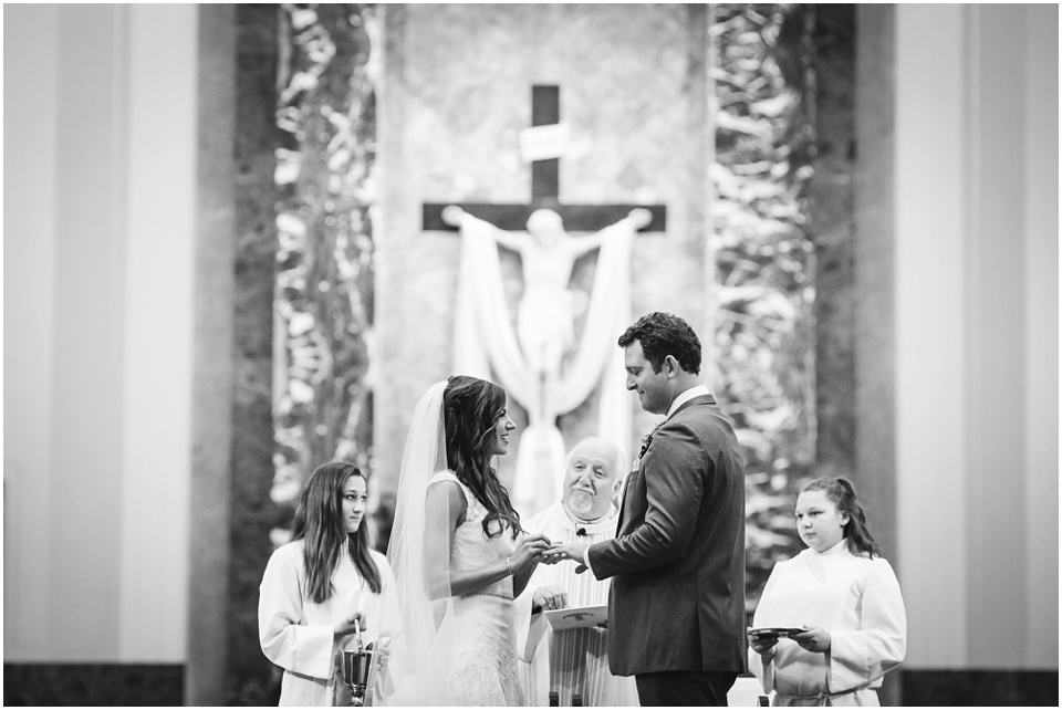 cathedral wedding photography, Bride and groom exchange rings at the altar.
