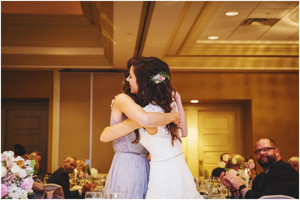 cathedral wedding photography, Bride hugging maid of honor after wedding toast.