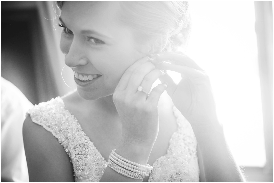 Bride puts on earrings by Central Illinois Wedding Photographer Rachael Schirano