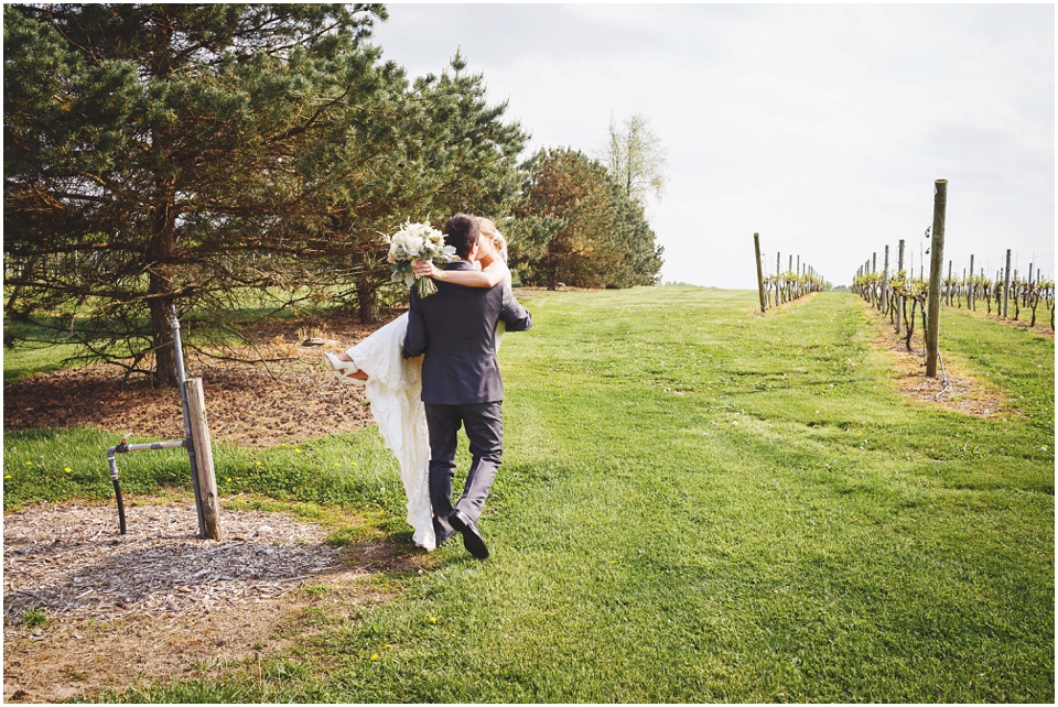 Groom carries bride through winery at Kickapoo Creek Winery Wedding by Wedding Photographer Rachael Schirano