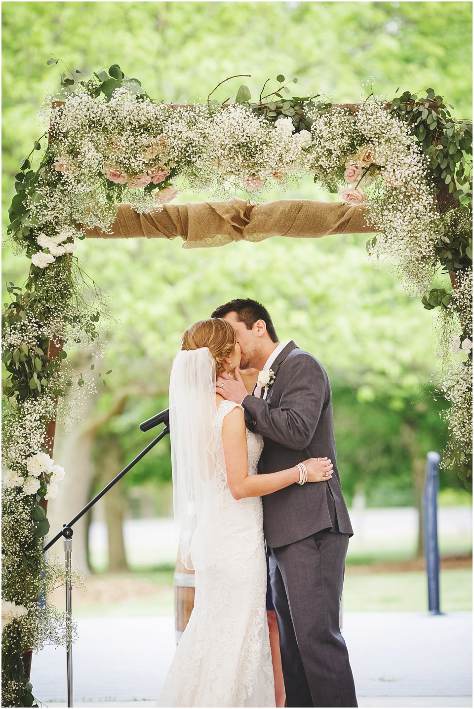 Bride and grooms first kiss at Kickapoo Creek Winery Pavillion Wedding Ceremony by Wedding Photographer Rachael Schirano