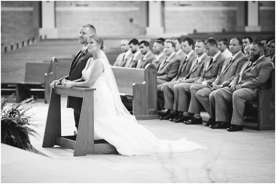 Bride and groom kneeling at Central Illinois church wedding.