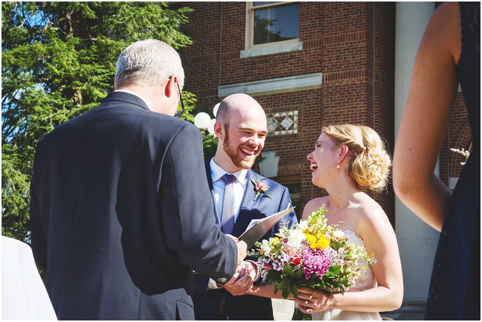 Bride and groom laughing at wedding ceremony at Central Illinois mansion with overlook