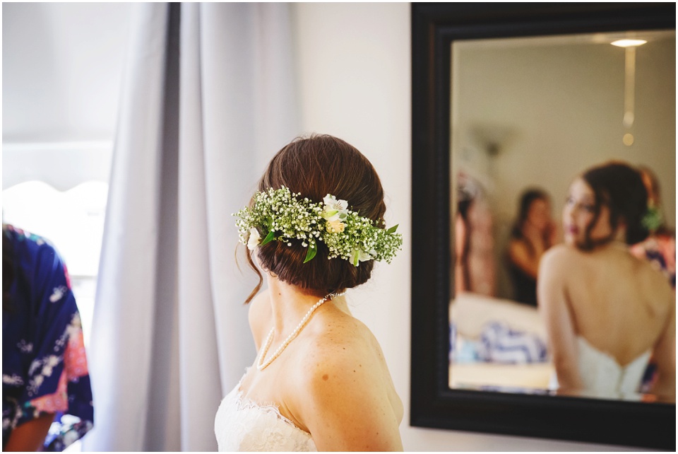 Bride looks at herself in mirror.