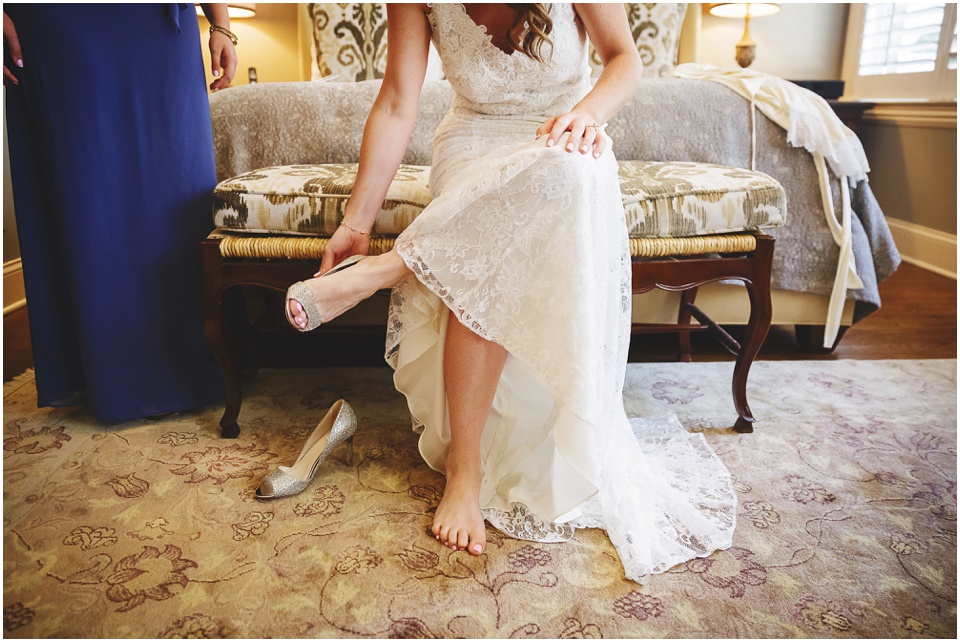 bride putting on wedding shoes by Chicago Wedding Photographer Rachael Schirano