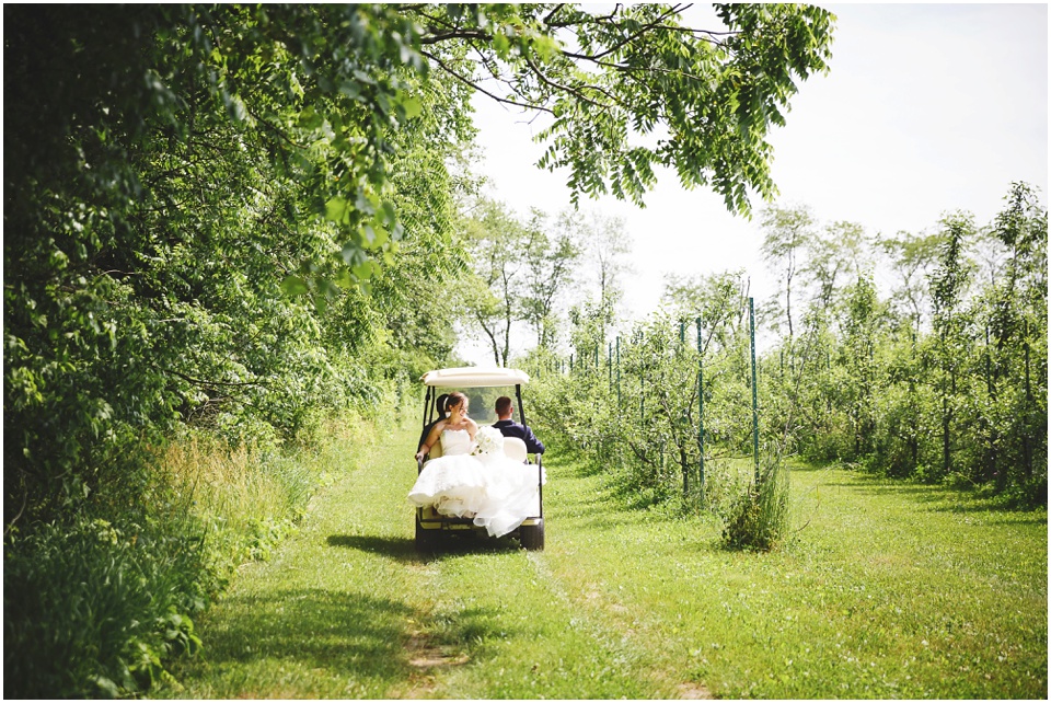 outdoor wedding photography, Bride and groom ride in golf cart by Bloomington Illinois Wedding Photographer Rachael Schirano