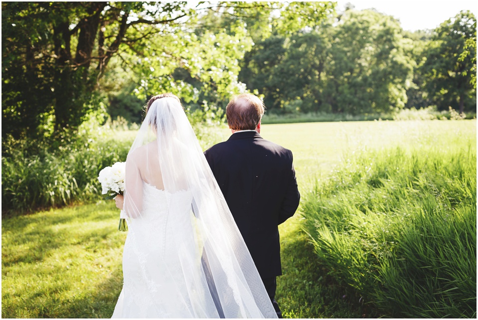 outdoor wedding photography, Father walks daughter down a field at a country wedding by Bloomington Illinois Wedding Photographer Rachael Schirano