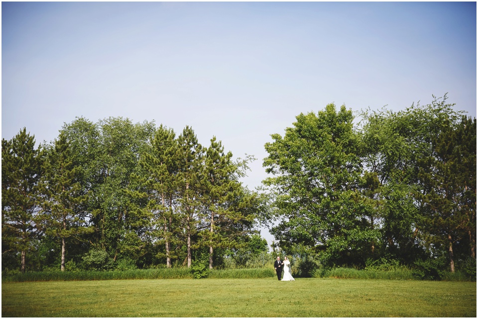 outdoor wedding photography, Bride walks down the aisle in a big open field at a country wedding by Bloomington Illinois Wedding Photographer Rachael Schirano