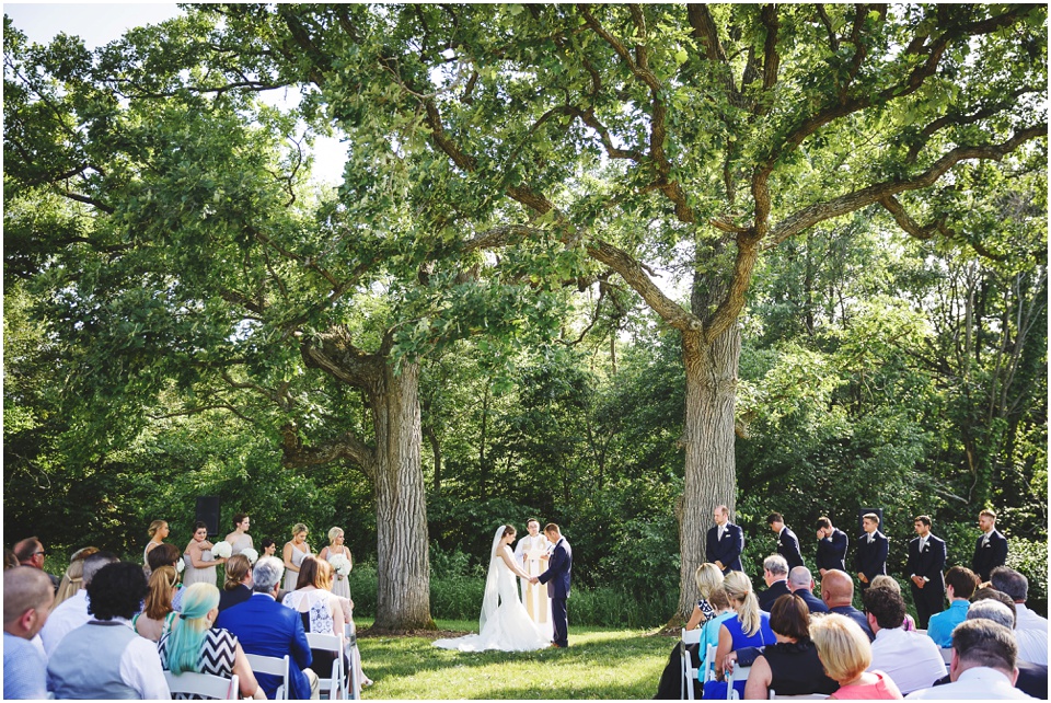 outdoor wedding photography, Country wedding ceremony between two huge trees by Bloomington Illinois Wedding Photographer Rachael Schirano