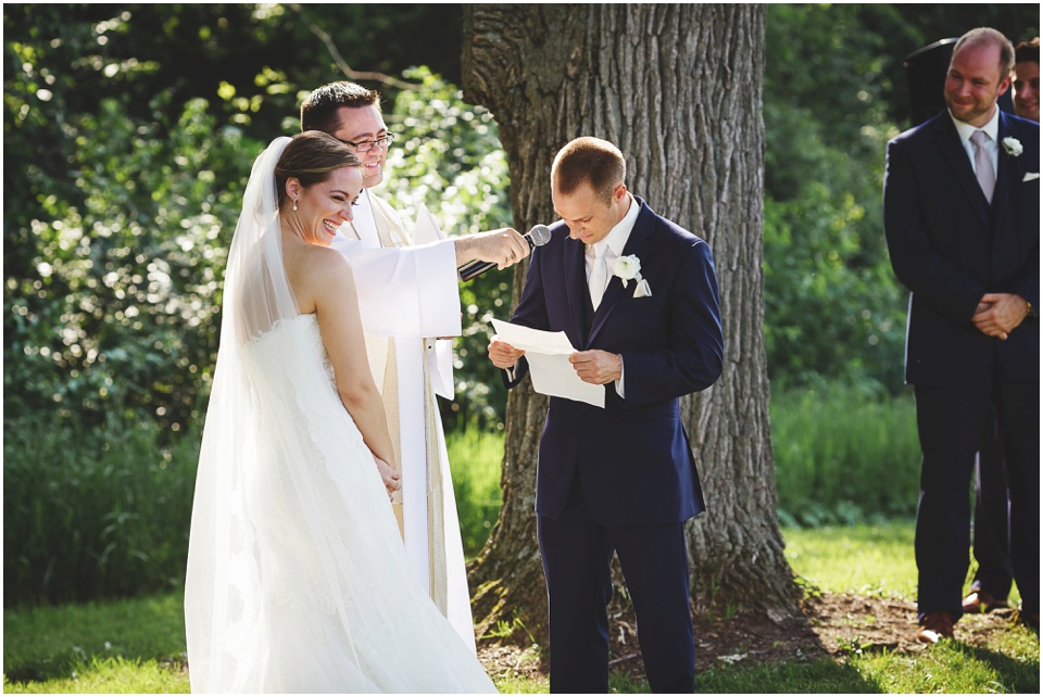 outdoor wedding photography, Bride and groom laugh during vows at wedding ceremony by Bloomington Illinois Wedding Photographer Rachael Schirano