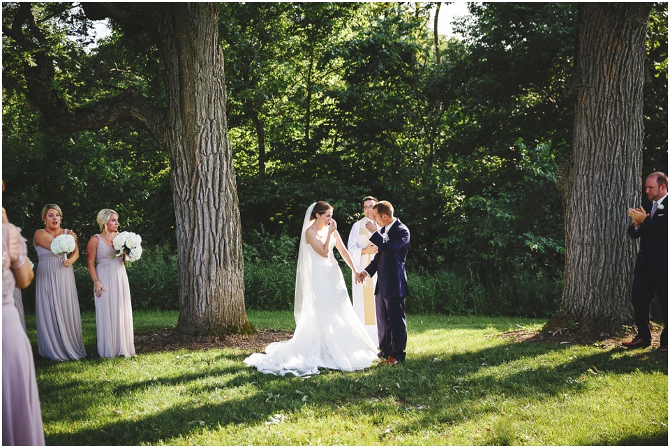 outdoor wedding photography, Wedding ceremony between two huge trees in a field in Illinois by Bloomington Illinois Wedding Photographer Rachael Schirano