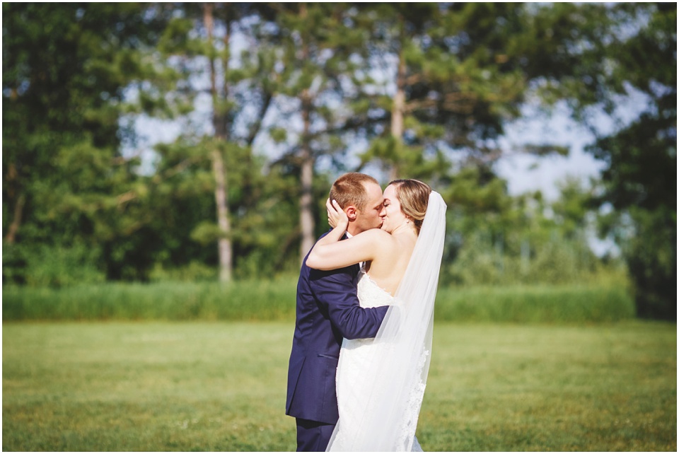 outdoor wedding photography, Bride and groom kiss after wedding by Bloomington Illinois Wedding Photographer Rachael Schirano