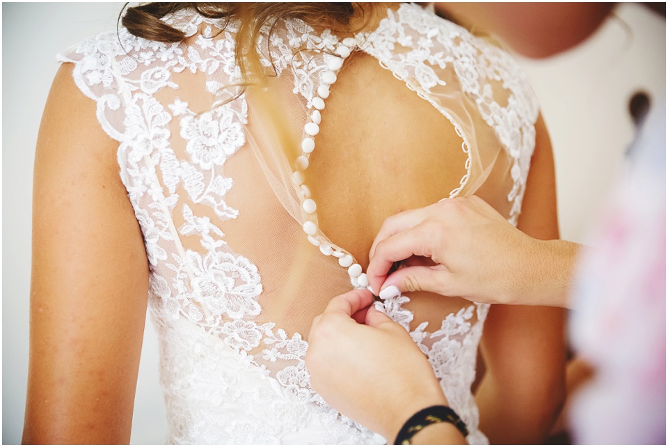 garden wedding photos, Buttoning up white wedding dress