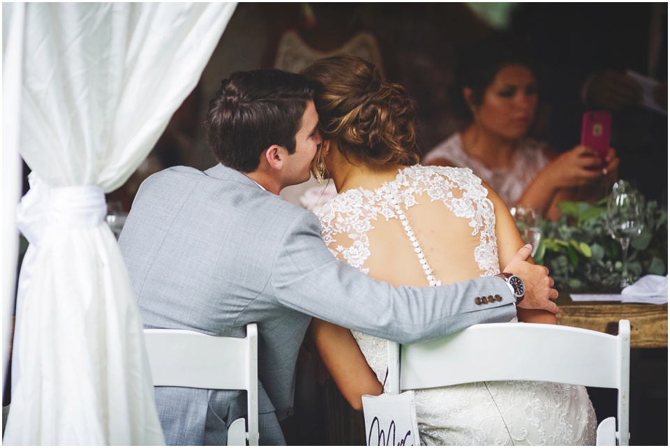 garden wedding photos, Groom whispering in brides ear at reception 