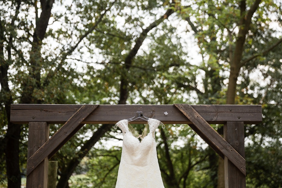 outdoor Illinois wedding photography, wedding dress hanging on wooden arbor