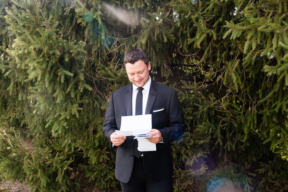 Groom reading letter from bride on wedding day