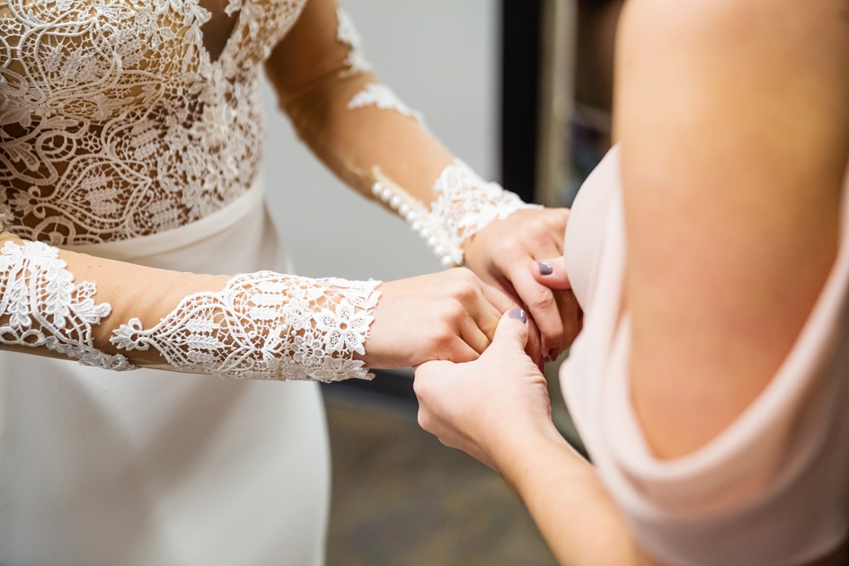 bride getting to lace wedding dress