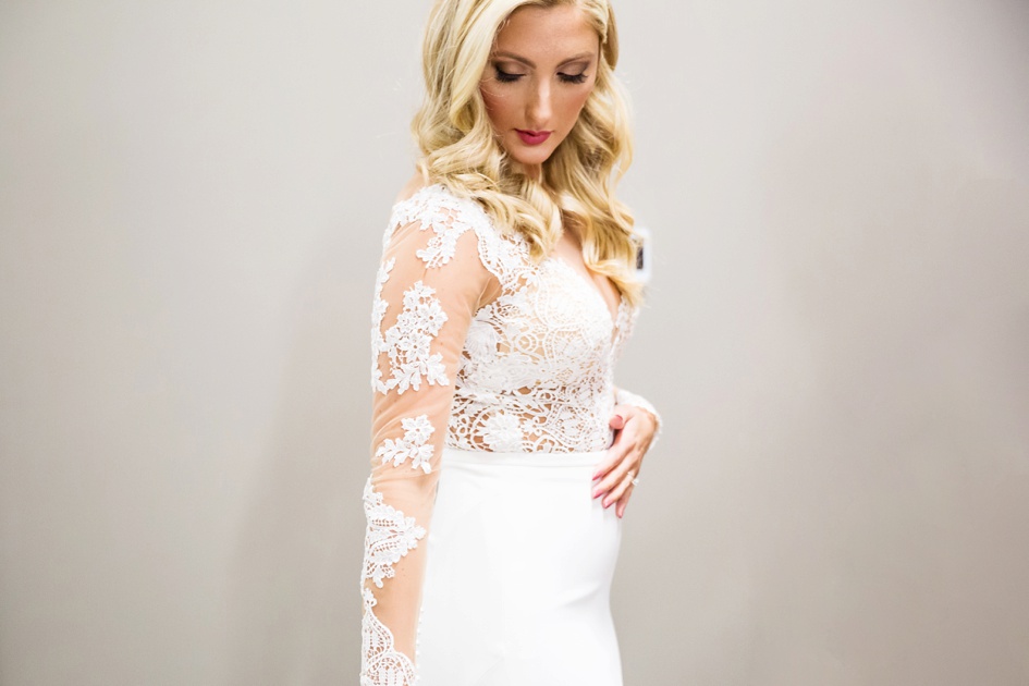 bride getting to lace long sleeve wedding dress