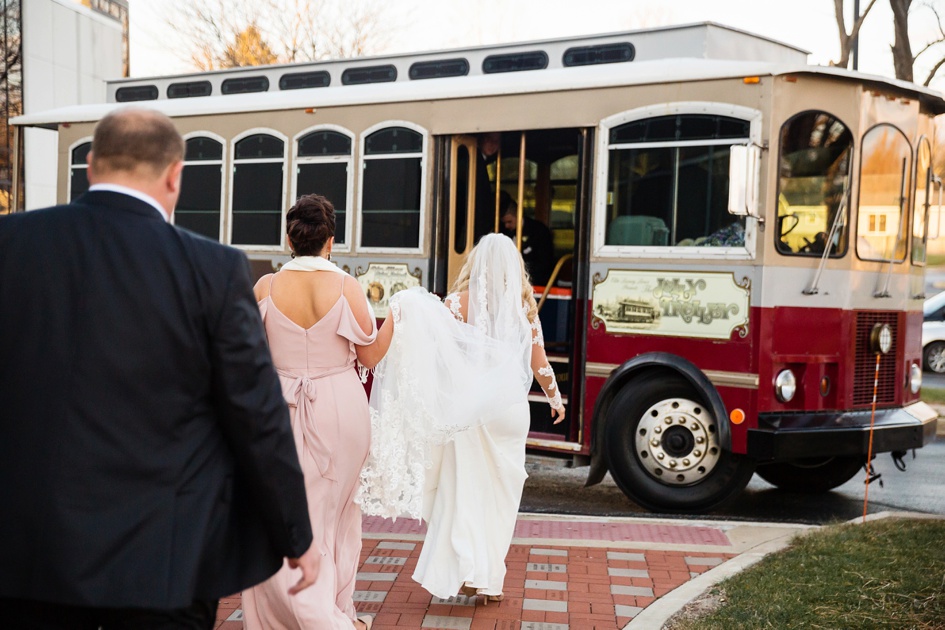 christmas themed church leaving wedding ceremony in red trolley