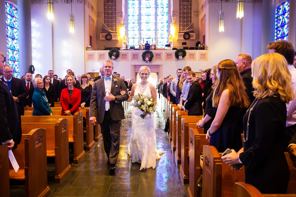 bride walks down aisle at christmas themed church wedding