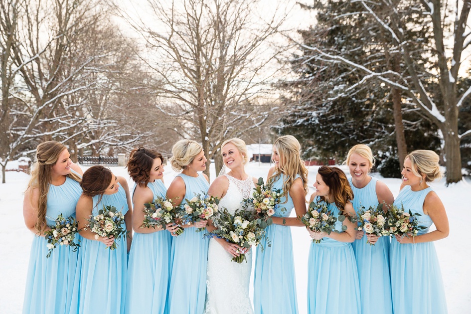 bright blue bridesmaid dresses and black suits in snowy winter wedding portraits