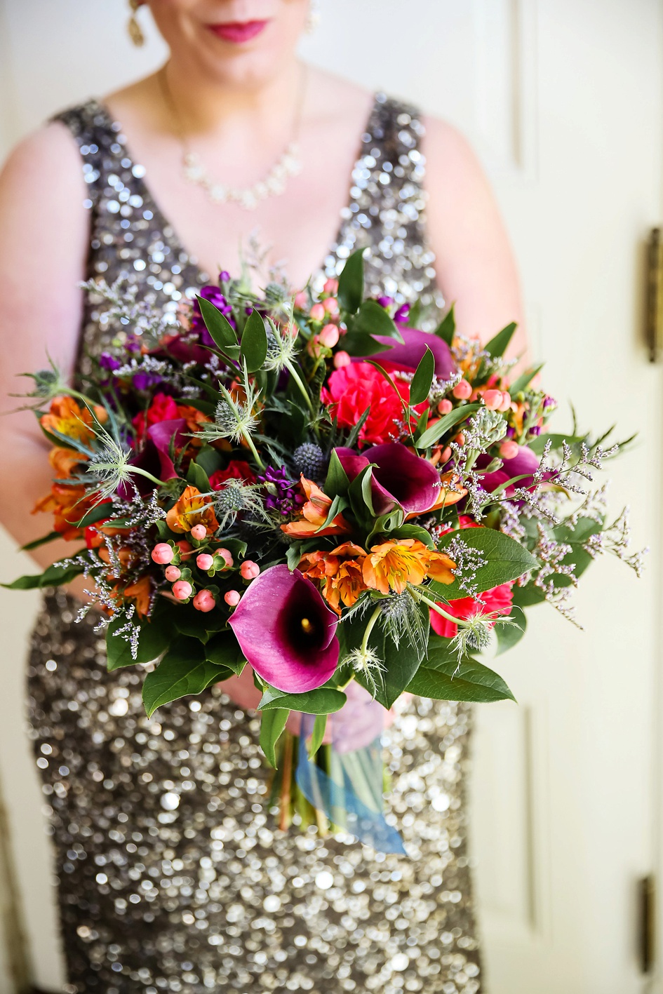 Bride wearing silver and grey sparkle wedding dress with colorful bouquet