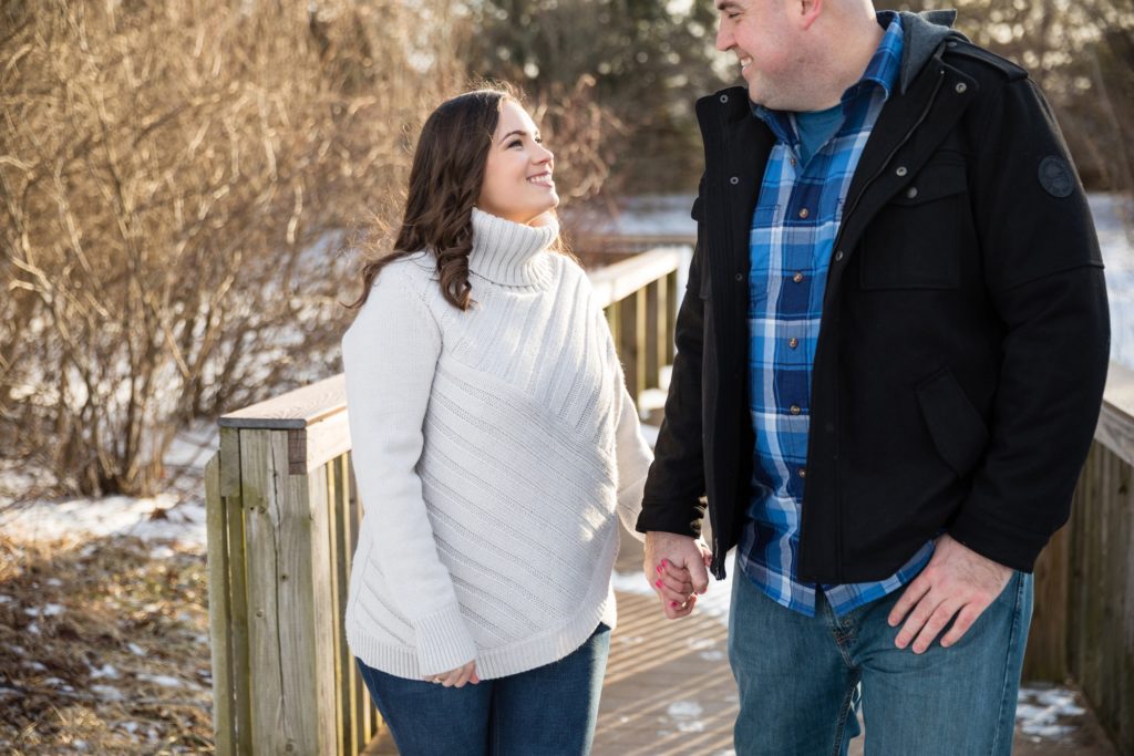 Bloomington IL winter engagement session, Central Illinois engagement photographer, winter engagement, snowy engagement photos, what to wear for a winter engagement, pine tree engagement photos, couple's portraits, engaged couple on a wooden bridge
